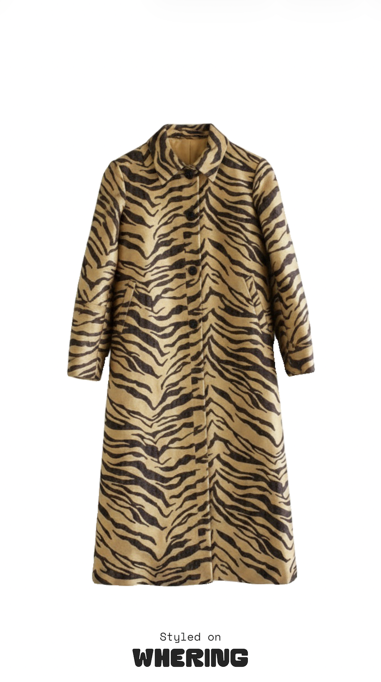 Long-sleeved, knee-length tiger-print coat in tan and black with a button front and collar, isolated on white; bold, stylish fashion look.