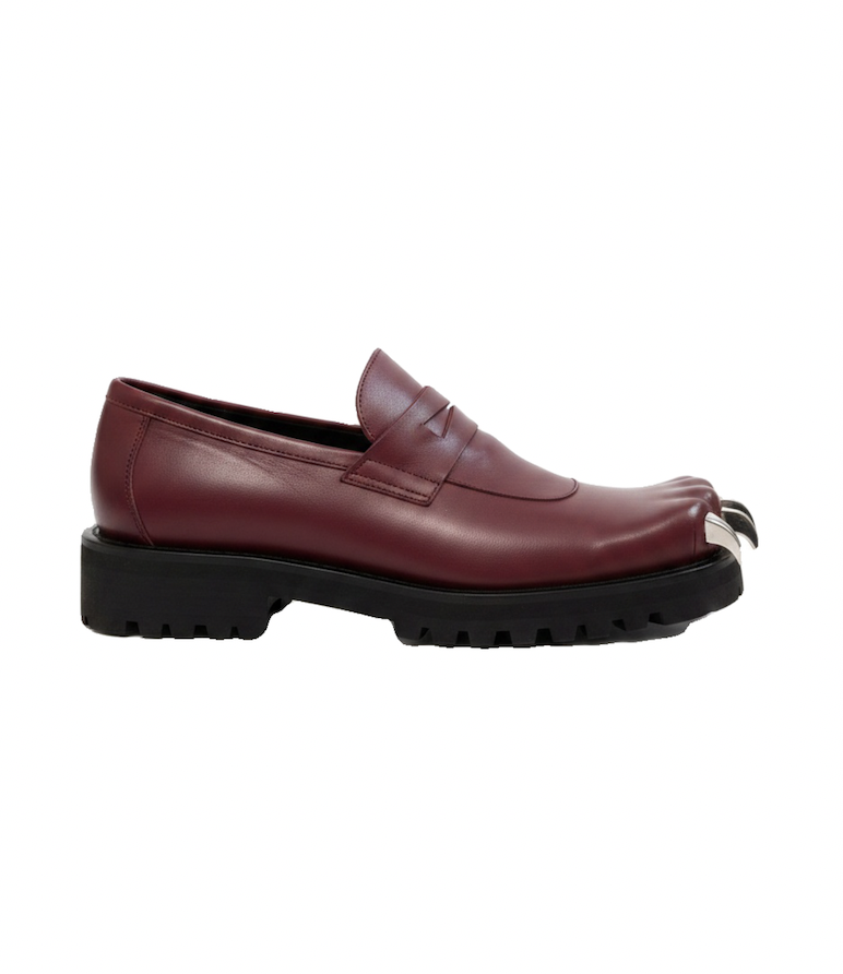 Side-profile burgundy leather loafer with a penny strap, chunky black lug sole, and metallic toe detail on a white background.
